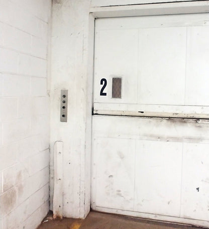 The number 2 printed as a 9 inch tall decal from the Stikons product line by InkBird Print Studio. Applied to an elevator door to indicate that you are on currently on floor 2.
