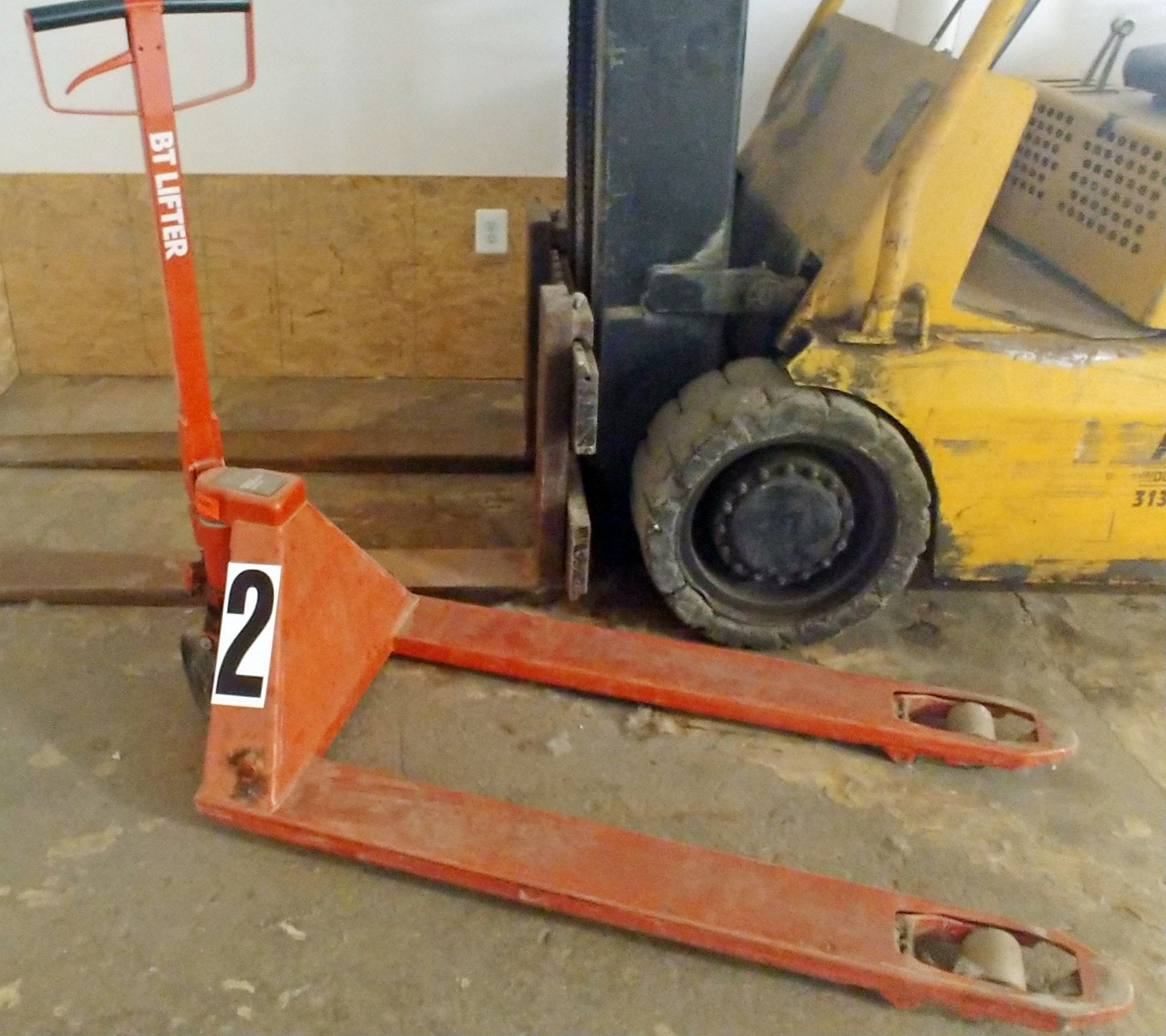 A 12inch tall decal with the number 2 on it, black ink on white matte vinyl, applied to a pallet jack to label it for warehouse use. 