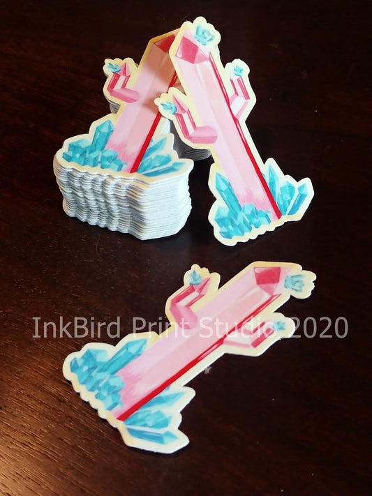 Crystal Cactus decals measuring 3"x 1.6" with pink crystal and blue accents are displayed on a dark surface. Some decals overlap, while others are spaced out to highlight the design. The text reads InkBird Print Studio LLC 2020. Perfect for laptops, gifts, water bottles, mirrors, lockers, and more!